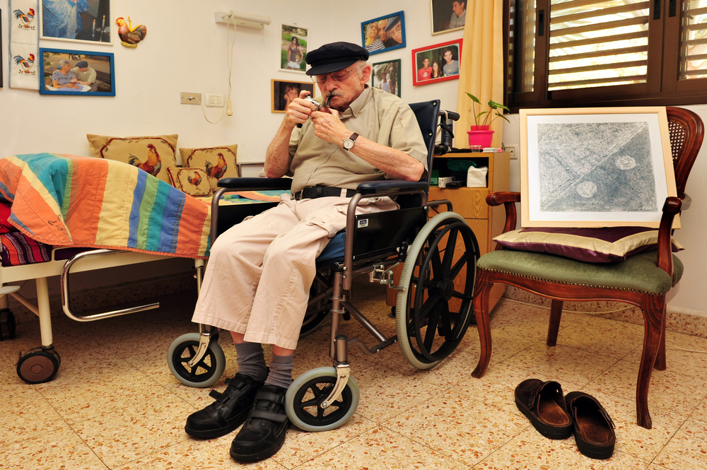 REHOVOT - JULY 17 2011:Disabled senior man smoking medical Cannabis at home.Marijuana is illegal in Israel but medical use has been permitted since the early 1990s for patients pain-related illnesses.