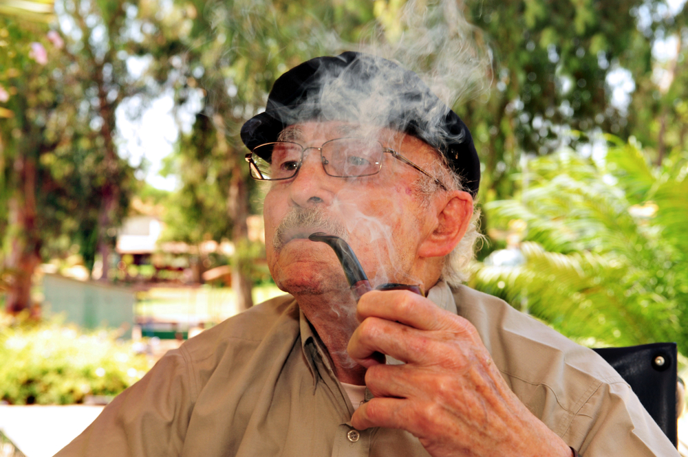 REHOVOT - JULY 17 2011:Senior man smoking medical Cannabis at home garden. Marijuana is illegal in Israel but medical use has been permitted since the early 1990s for patients pain-related illnesses.