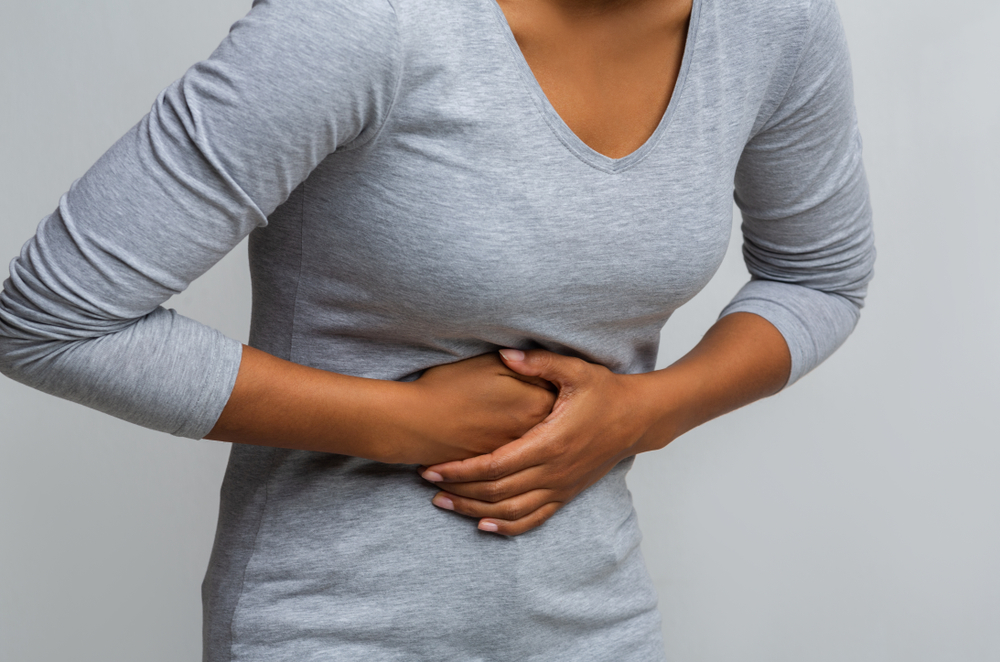 Cropped of black woman suffering from gastritis, touching her tummy