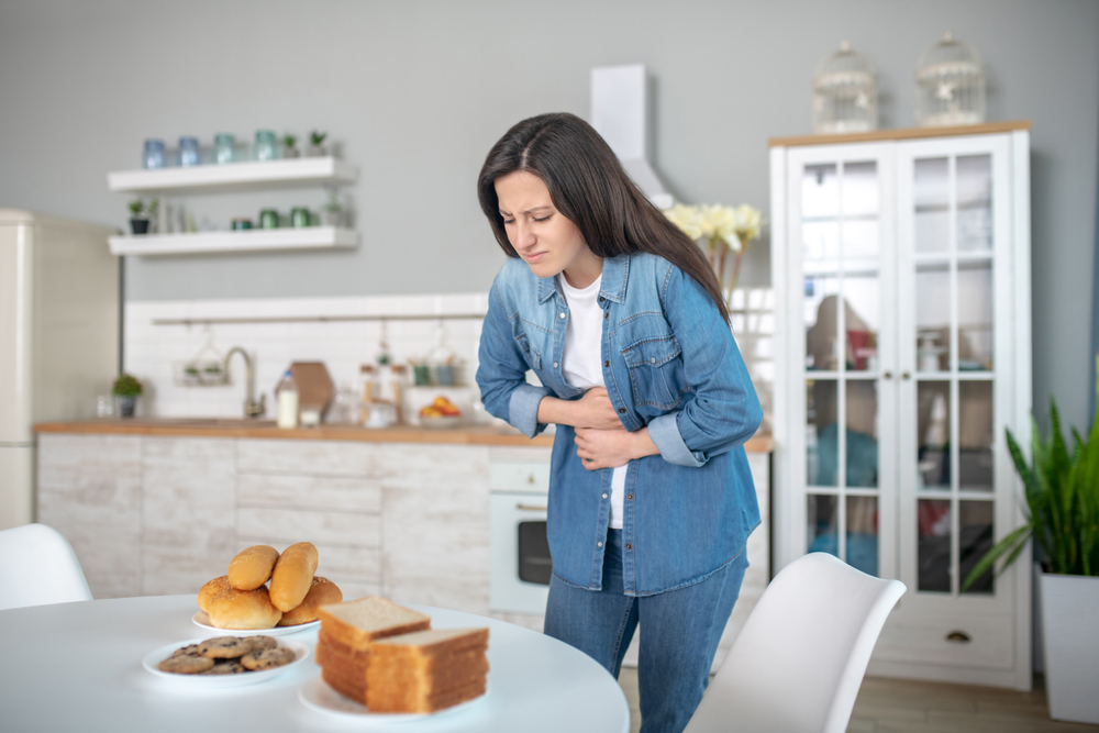 Healt issues. A woman having a stomach ache because of gluten intolerance
