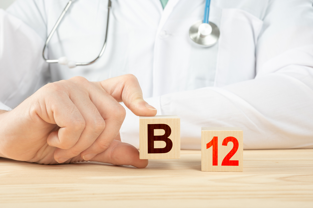 essential vitamins and minerals for humans. doctor recommends taking vitamin b12. doctor talks about the benefits of vitamin b12. B12 Vitamin - Health Concept. B12 alphabet on wood cube.