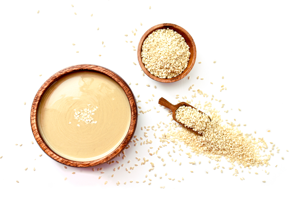 Homemade tahini or tahina, paste from ground sesame seeds isolated on white, top view
