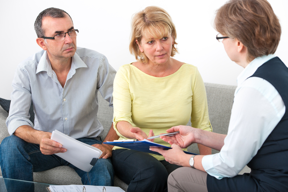 Mature couple getting financial advice from consultant at home