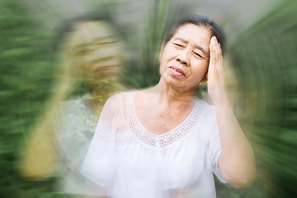 old elderly Asian feeling faint and dizzy from hot weather