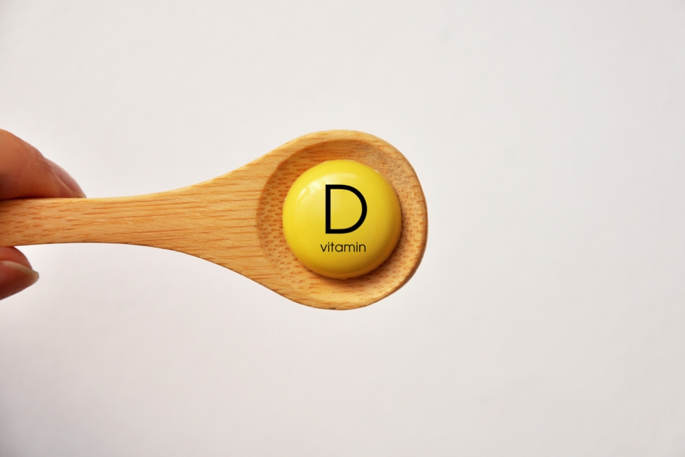 A tablet with the inscription Vitamin D on a spoon
