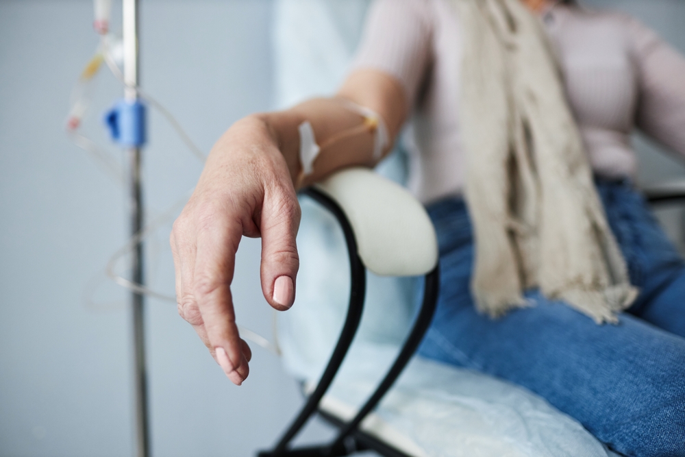 Closeup of woman in treatment session at hospital with IV drip infusion in hand, copy space
