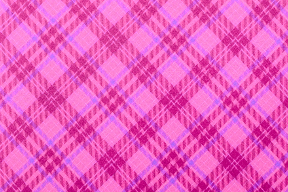 Christmas violet purple checkered background, texture seamless pink pattern fabric checkered, gingham backdrop. Plain classic Scottish plaid design. Suitable flannel pink textile. top view of table.
