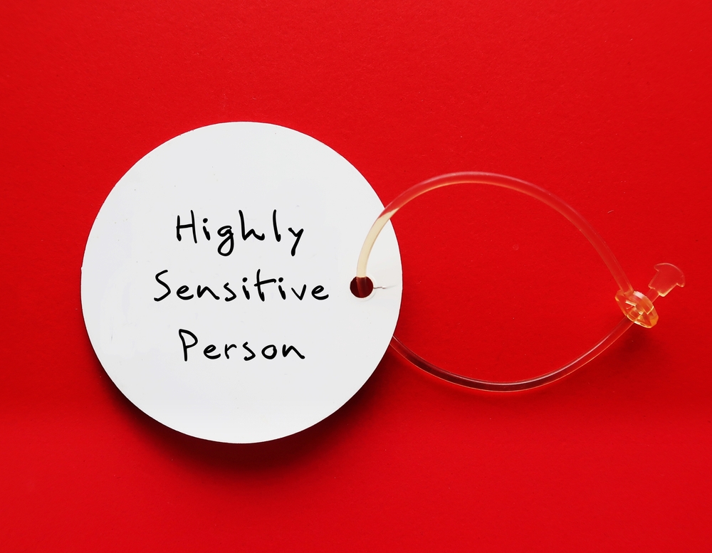 Tag on red background with handwritten text HIGHLY SENSITIVE PERSON, refers to people who think and feel everything more deeply, more sensitive to the environment and social interactions
