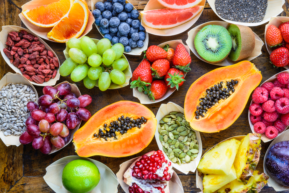 Fruits, berries, nuts, seeds top view on rustic wooden background.Diet, detox, superfood concept.