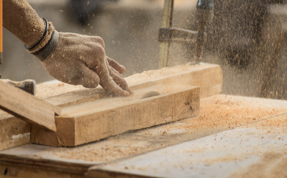 Handmade and craft furniture concept: Carpenter engaged in processing wood at the sawmill