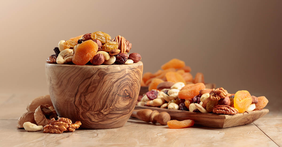 wooden bowel filled with various dried fruits and nuts