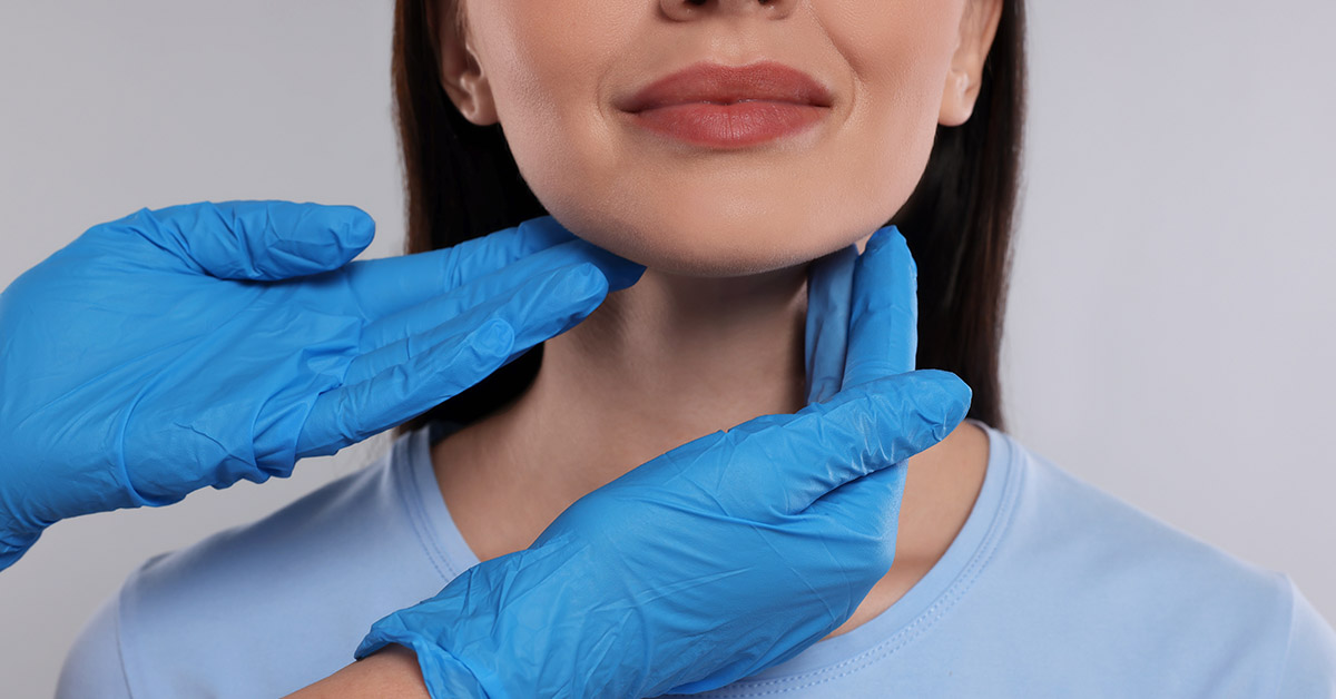 hands wearing blue surgical gloves examining women's neck
