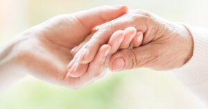 one hand holding another person's hand
