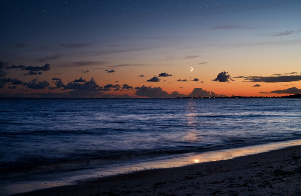 Sunset with moon over beach