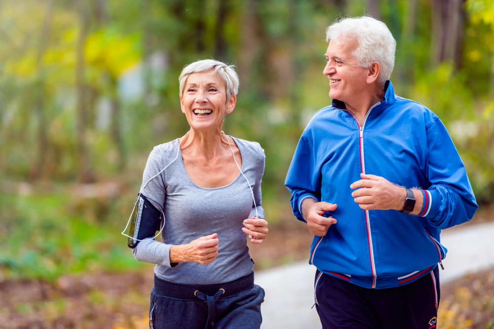 Smiling senior couple jogging in the park
