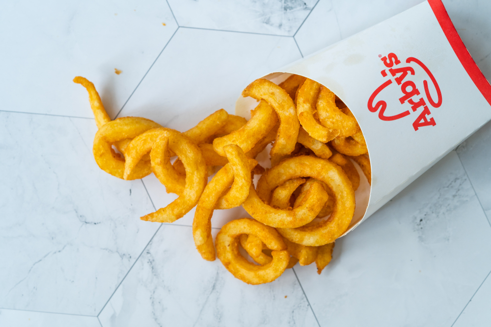 Istanbul, Turkey - February 23, 2018: Arbys Take Away Curly Fries Ready to Eat with Sauce in Plastic Box Package / Container. Fast Food.