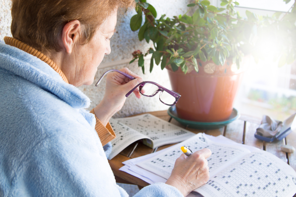 senior woman doing crossword puzzles or hobbies sitting
