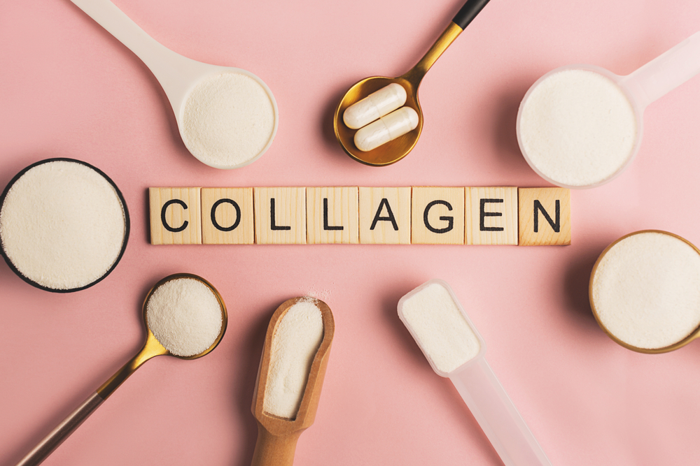 Collagen powder and pills spoons on pink background. Extra protein intake. Natural beauty and health supplement for skin, bones, joints and gut. Plant or fish based. Flatlay, top view. Copy space.
