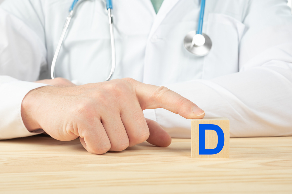 essential vitamins and minerals for humans. doctor recommends taking vitamin D. doctor talks about the benefits of vitamin D. D Vitamin - Health Concept. D alphabet on wood cube.