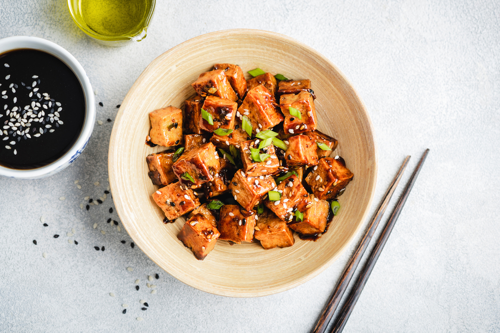 Fried teriyaki tofu with scallions and sesame seeds. Healthy vegan meatless meal rich in protein and calcium. Asian tofu meal