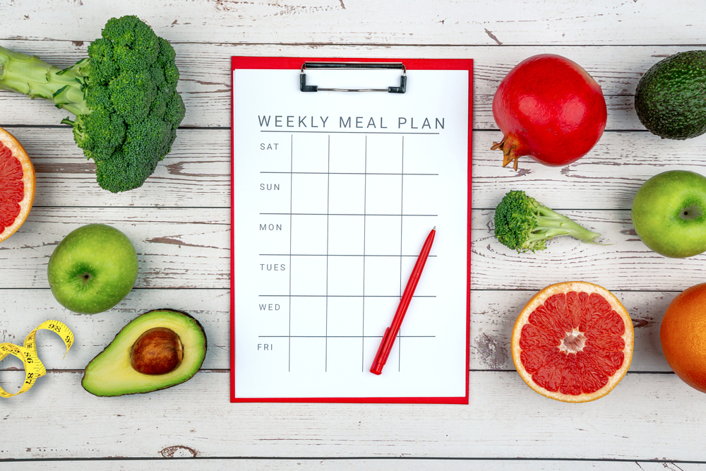 Healthy lifestyle workout concept with training equipment. The idea of how to achieve harmony and longevity while Slimming. Weekly meal plan tab