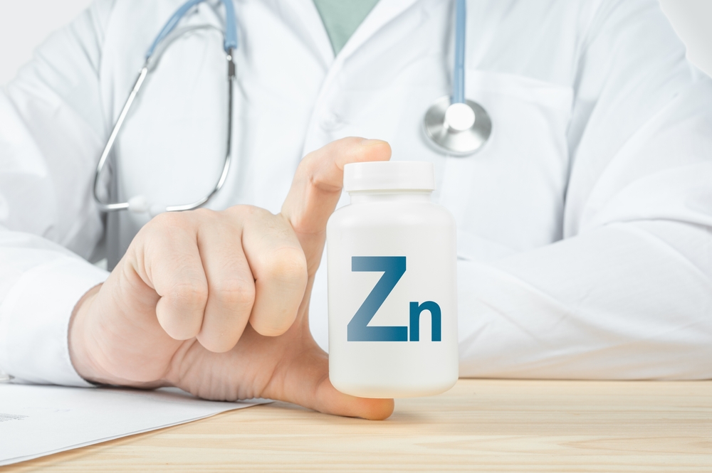 Iron Zinc Zn supplements for human health. Doctor recommends taking Zinc Zn iron. doctor talks about Benefits of Zinc. Essential vitamins and minerals for humans. Zn Health Concept. Blue background