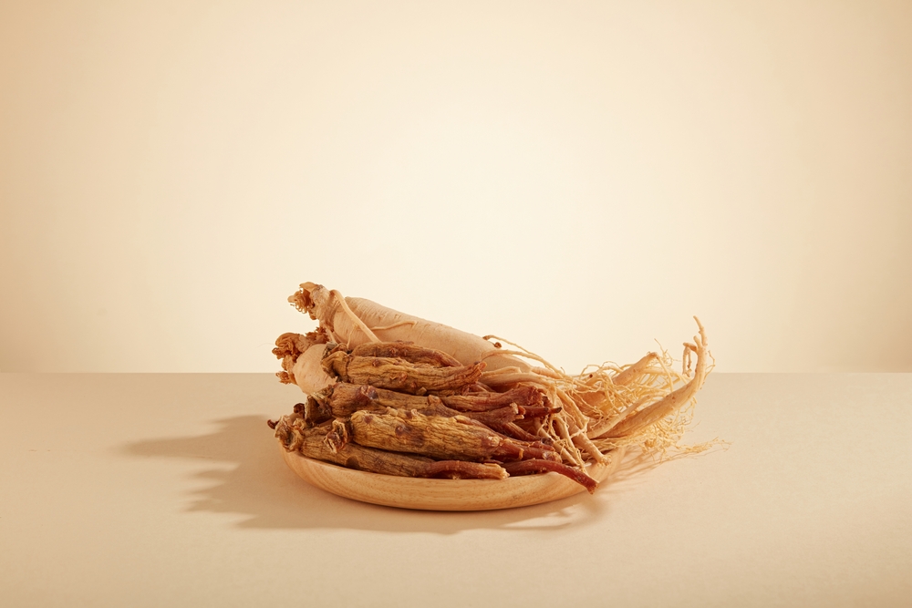 A front view of ginseng decorated in wooden dish in brown background 