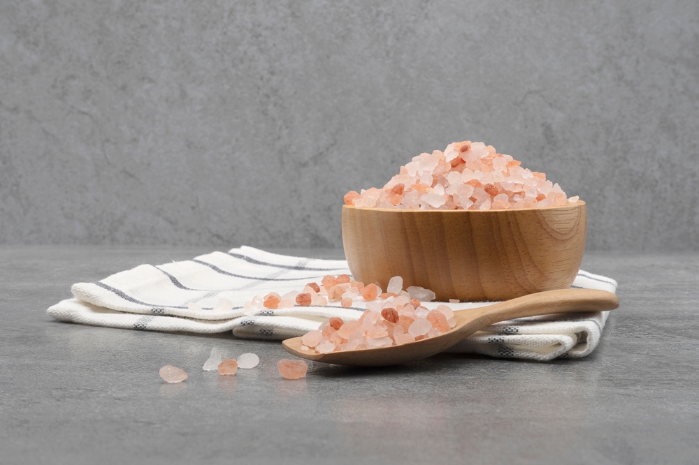 Himalayan pink salt in a wooden cup on a cloth
