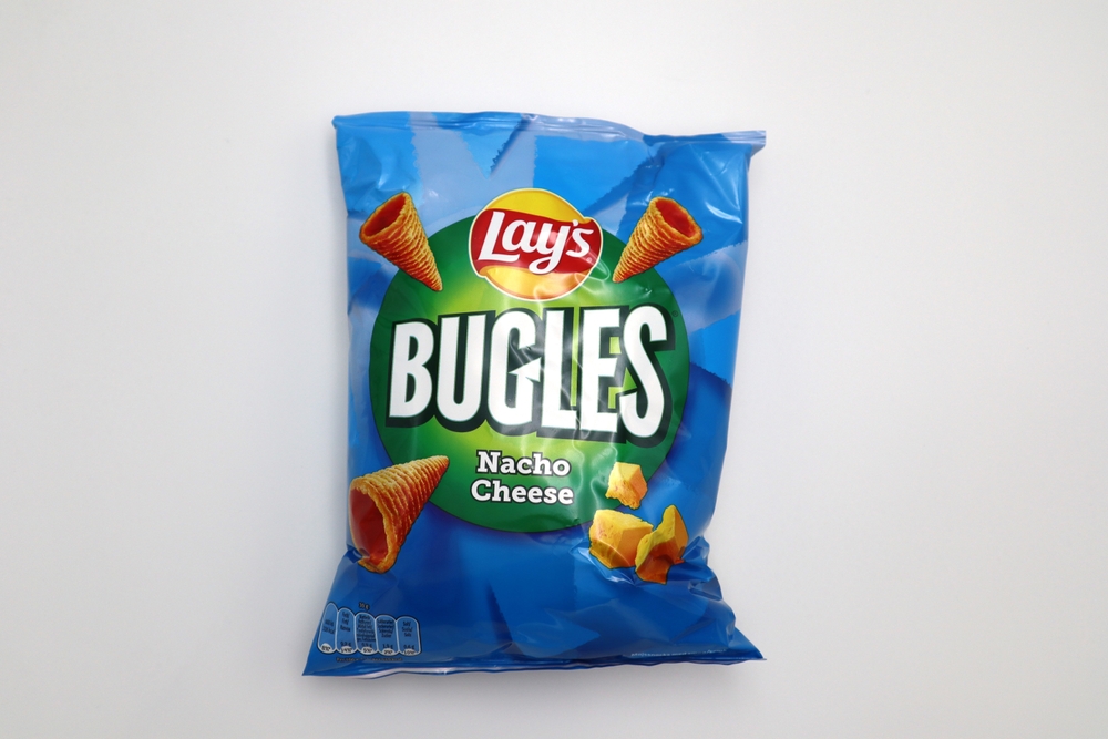 Kongsvinger, Norway 17 April 2023: Lays Bugles Nacho Cheese salty rolled corn crisps spices flavors bag package savory snacks food isolated on white background