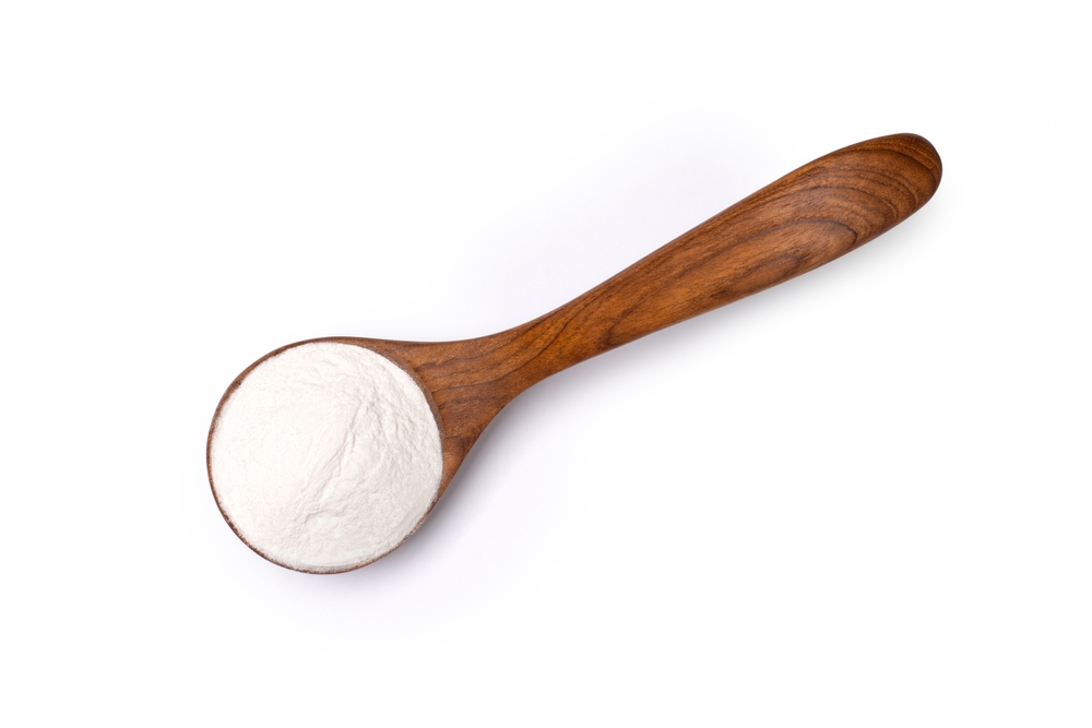 Collagen powder in wooden spoon isolated on white background. Natural supplement for human skin, bones and joints concept. Clipping path. Top view, flat lay.