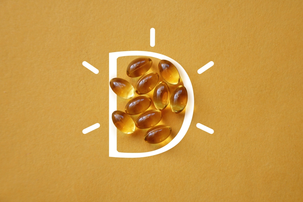 Vitamin D in capsules on a yellow background
