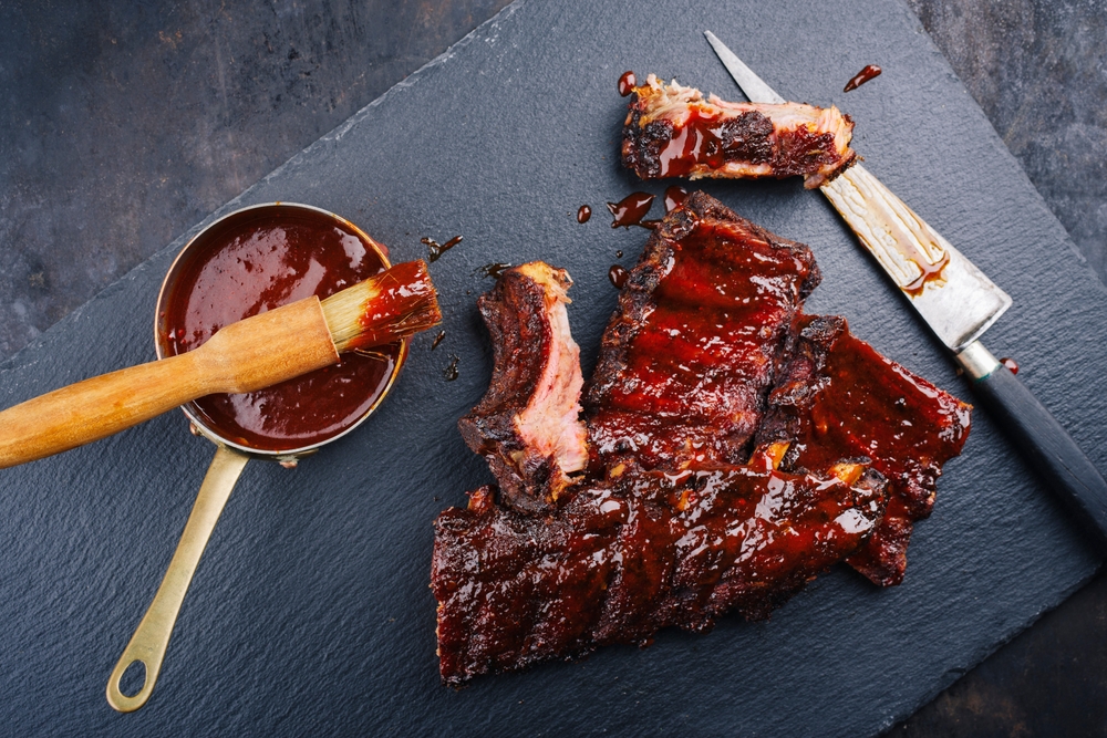 Barbecue pork spare loin ribs St Louis cut with hot honey chili marinade served as top view on a black board