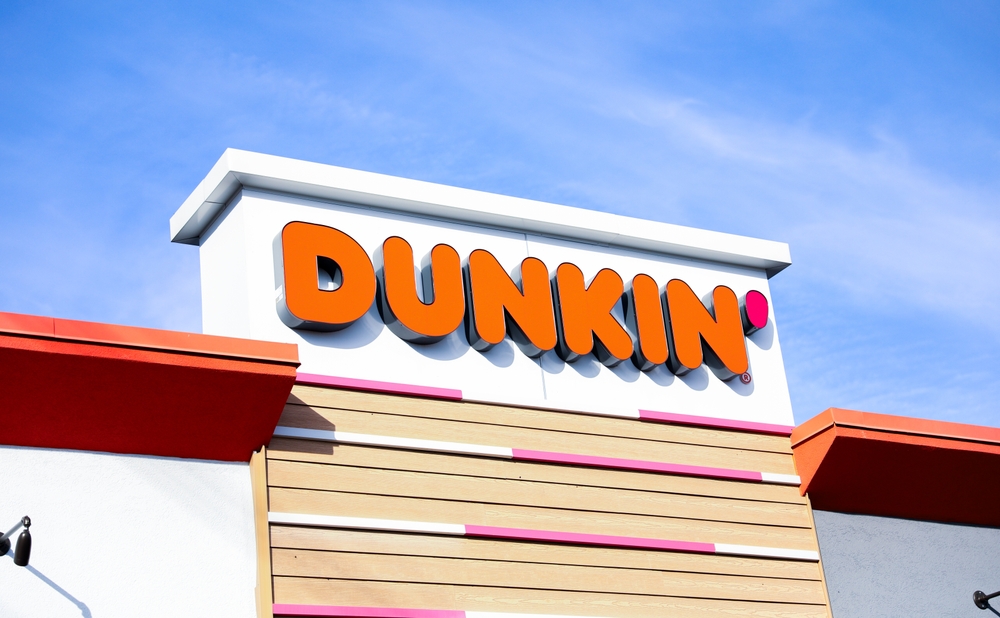 Chicago, IL, USA, December 3, 2023, Dunkin' Donuts sign illuminating a stack of branded boxes, inviting and delicious treats on display