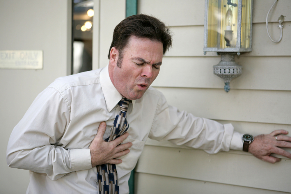 A middle aged man outside his office suffering from a persistent cough.
