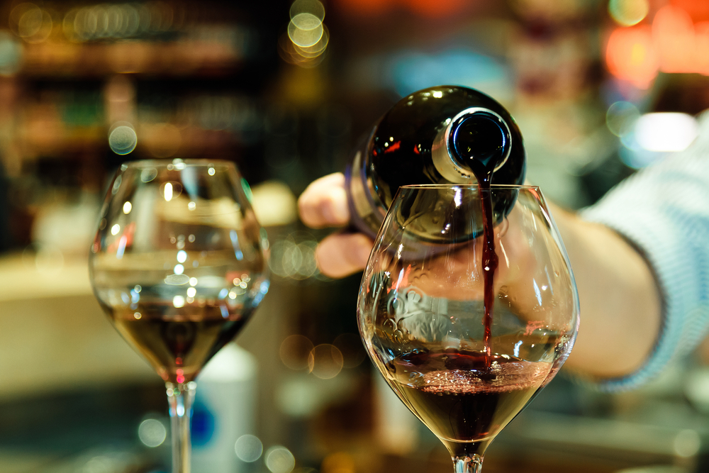 Red wine pouring into a wine glass. Shallow depth of field.
