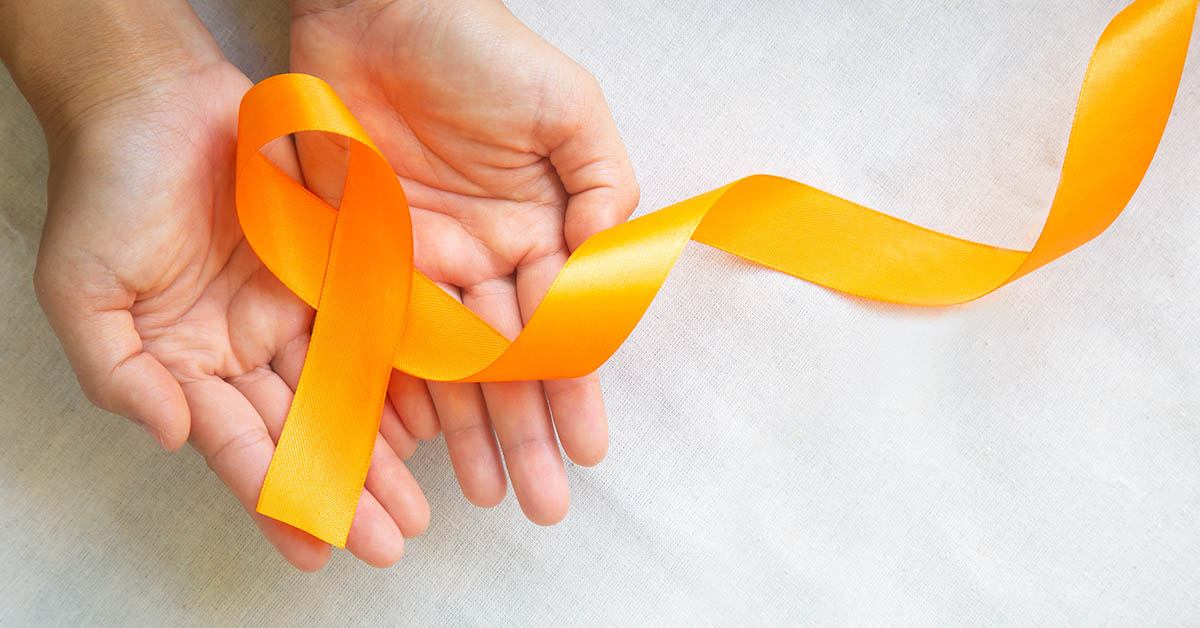 Hands holding orange cancer ribbon representing leukemia