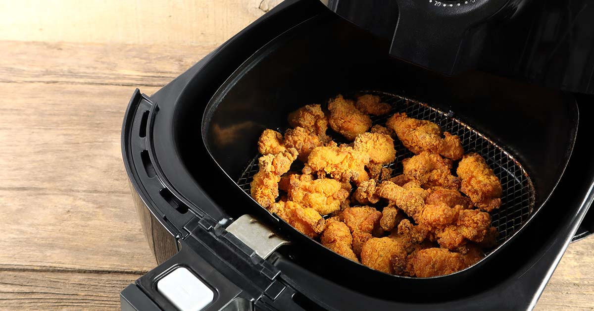 air fryer basket containing fried chicken