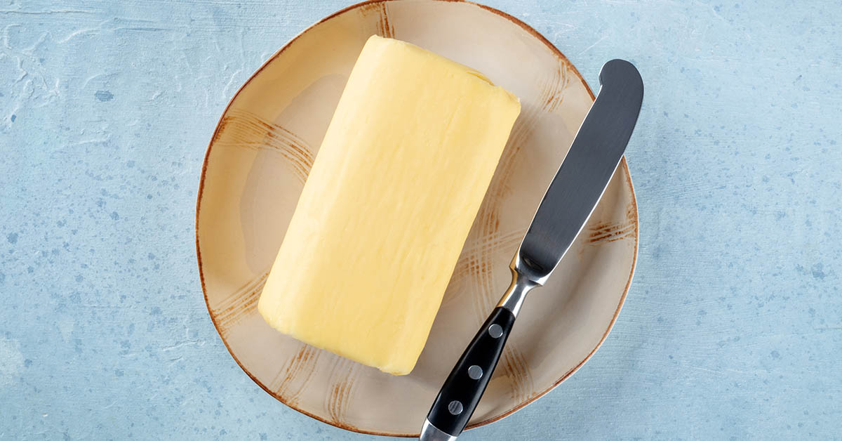 butter on plate with butter knife beside it