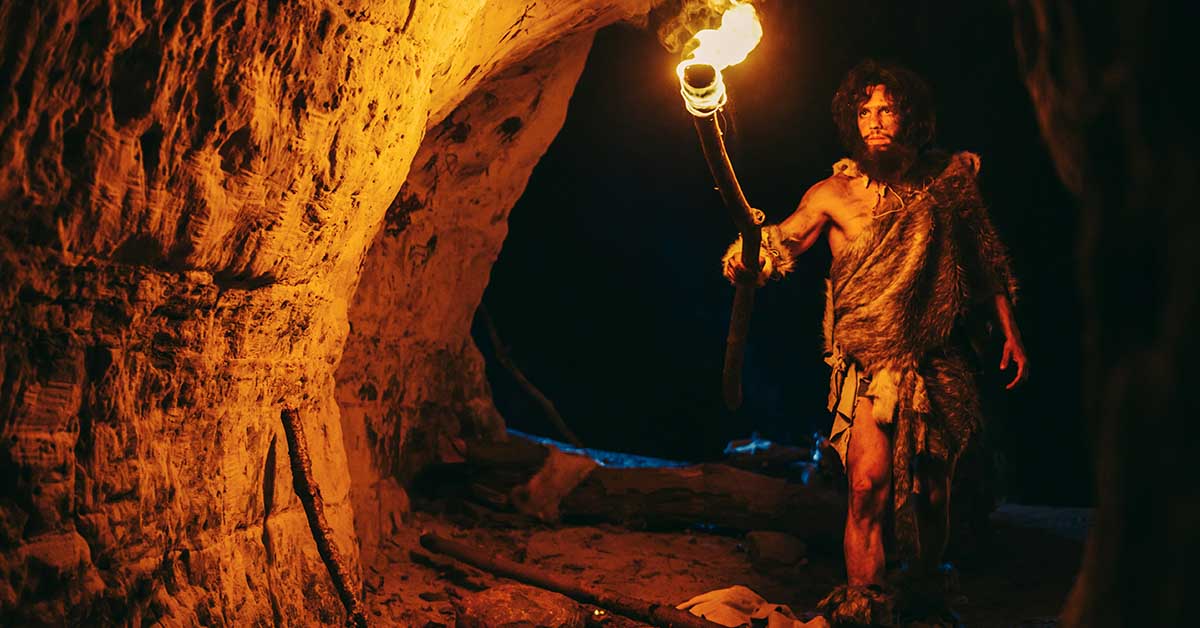 caveman using fire lit torch