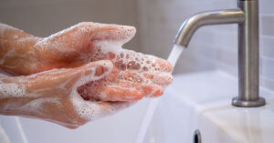 Wash Your Hands Immediately After Touching These 10 Things person washing their hands with soap under running water in sink