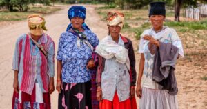 Basarwa four african women walking on dirt road, San people, village in Kalahari