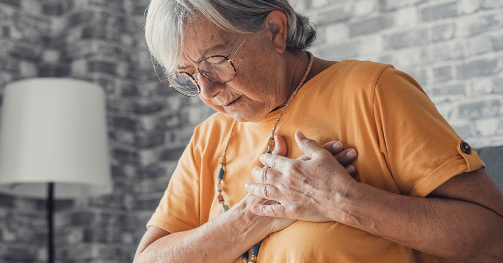 woman clasping hands over chest. Congestive Heart Failure concept
