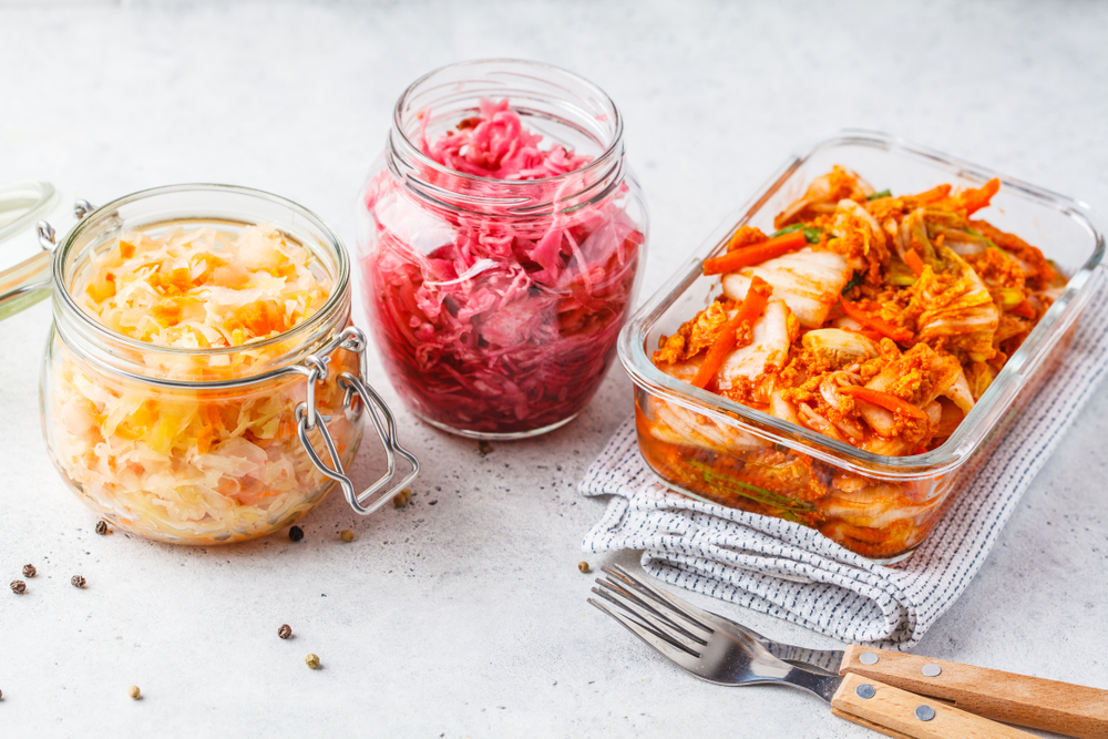 Korean kimchi cabbage, beet sauerkraut and sauerkraut in glass jars, white background. Probiotics food concept.
