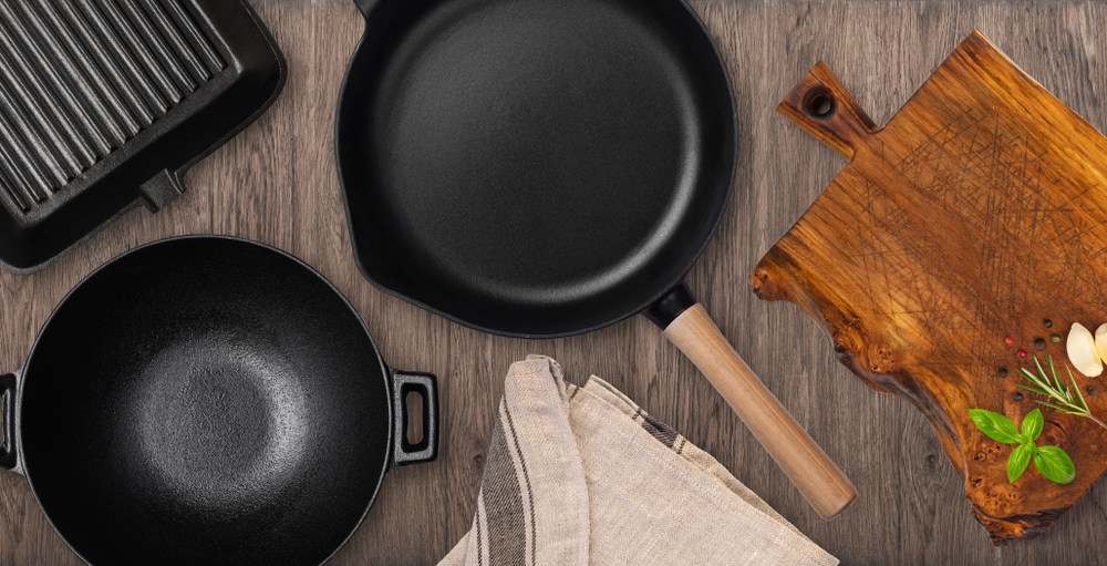 Empty cast iron frying pan on dark culinary background, view from above. Food background
