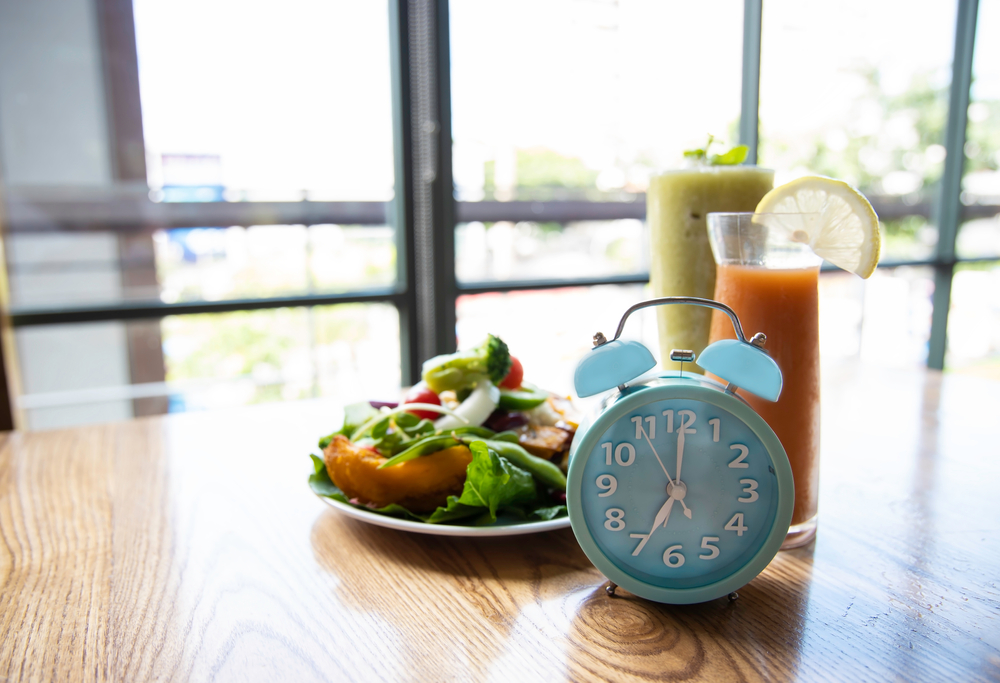 Selective focus of blue clock intermittent fasting  image as  window background,ketogenic diet, weight loss concept

