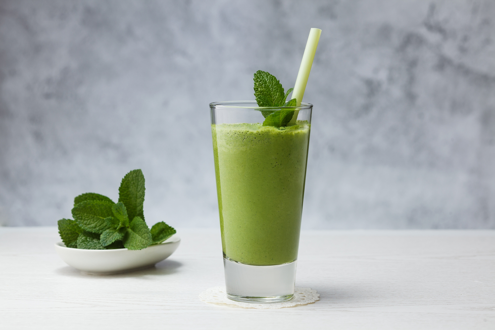 Healthy drink. Smoothies with banana, avocado, spinach, lime on a gray background.