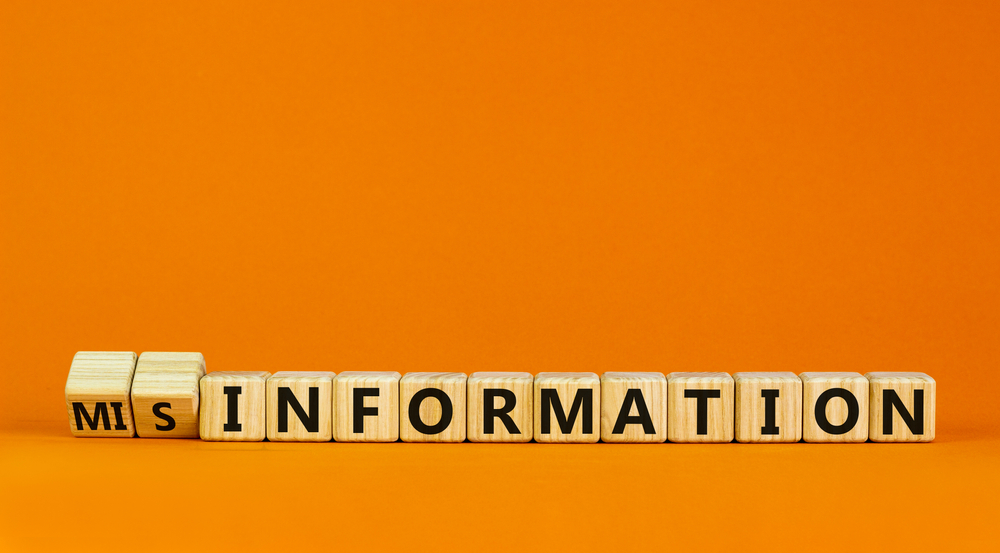 Information or misinformation symbol. Turned cubes and changed the word misinformation to information. Orange background, copy space. Business and information or misinformation concept.
