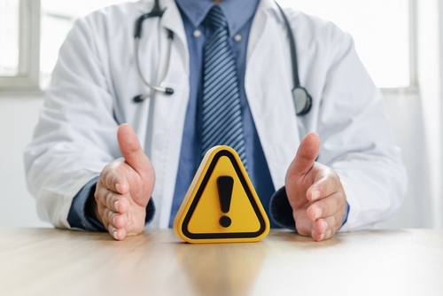 Warning symbol in hand of doctor. Doctor's warning, Precautions for epidemic diseases, Concept of caution.
