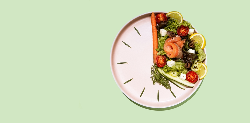 intermittent fasting concept clock dish with vegetables and salmon, fish, salad