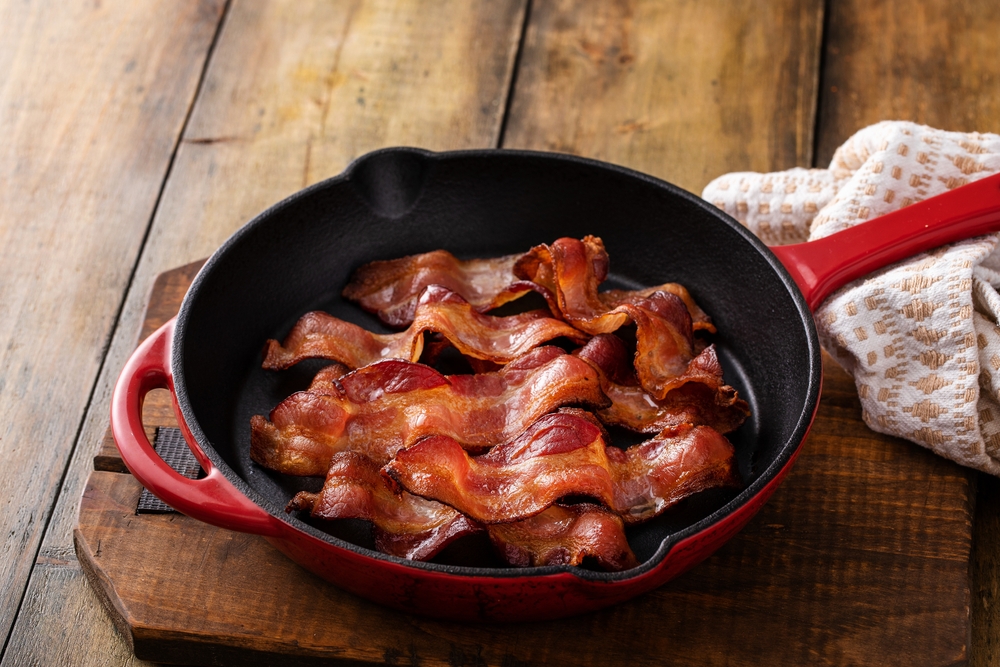 Cooked bacon in a cast iron pan, ready to eat breakfast staple
